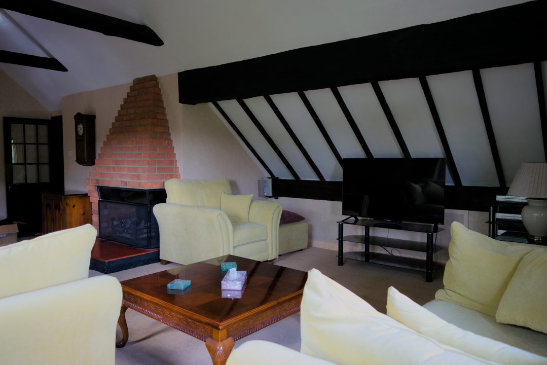 The lounge with double height ceiling, open fire and big screen TV